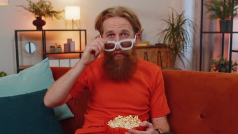 Mann-Sitzt-Auf-Der-Couch,-Isst-Popcorn-Und-Schaut-Sich-Zu-Hause-Interessante-Fernsehserien-Und-Sportspiele-Online-An