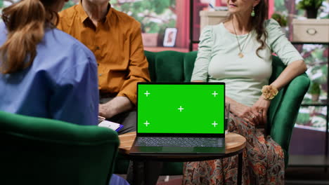 Nurse-giving-professional-advice-to-her-senior-patients-next-to-green-screen