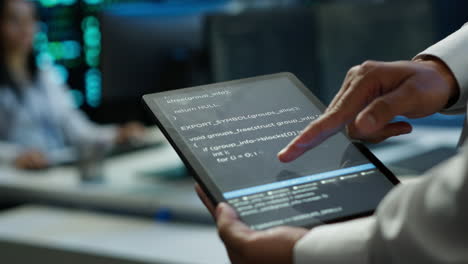 Close-up-of-tablet-used-by-IT-worker-doing-maintenance-on-server-farm-gear