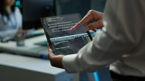 Programmer-using-device-in-data-center,-close-up