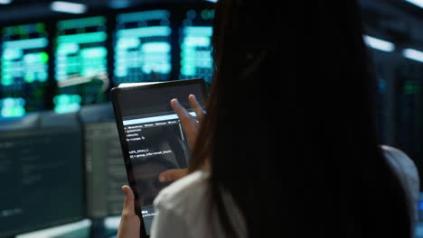 Close-up-of-woman-doing-maintenance-in-server-room-using-tablet