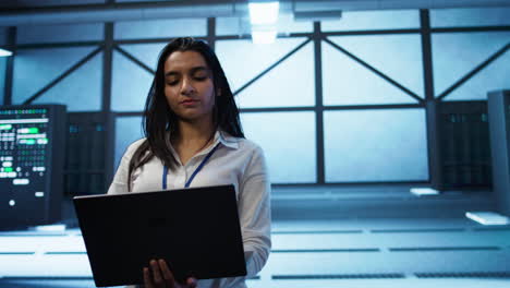 Tracking-shot-of-woman-in-server-hub-ensuring-networks-are-secure