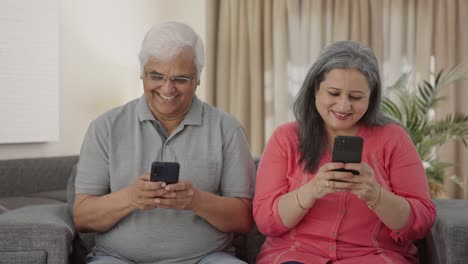 Happy-Old-Indian-couple-busy-in-their-phones