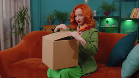 Happy-redhead-woman-shopper-unpacking-cardboard-box-delivery-parcel-online-shopping-purchase-at-home