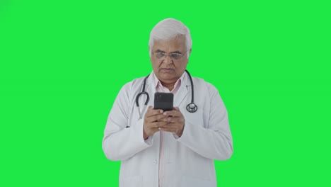 Médico-Senior-Indio-Enojado-Charlando-Con-Alguien-Pantalla-Verde