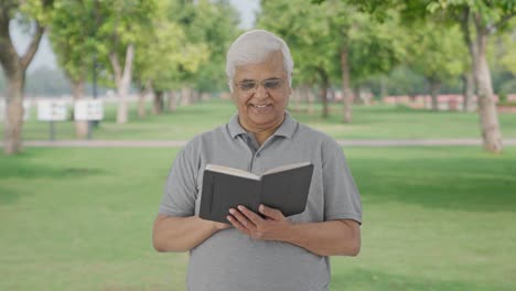 Happy-Indian-old-man-reading-a-book-in-park