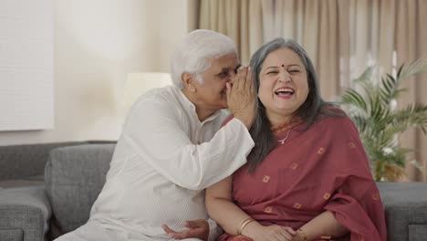 Happy-Old-Indian-husband-telling-a-secret-to-his-wife