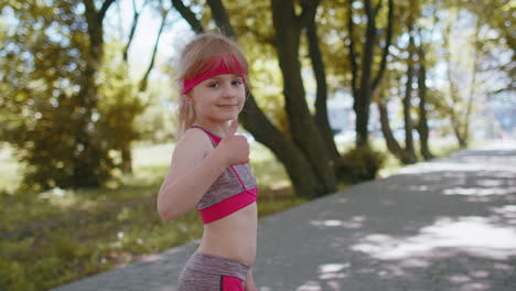 Back-view-of-athletic-sport-runner-girl-kid-training-marathon-run,-starting-race-showing-thumbs-up