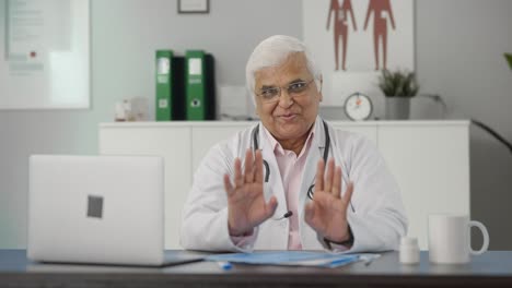 Happy-Indian-senior-doctor-talking-to-the-patient