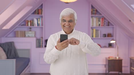 Indian-old-man-scrolling-through-phone