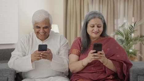 Happy-Old-Indian-couple-busy-in-their-phones