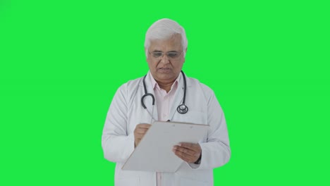 Médico-Senior-Indio-Escribiendo-Receta-En-Pantalla-Verde