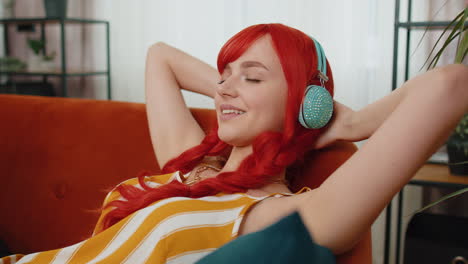 Girl-in-wireless-headphones-listening-favorite-disco-music-relaxing-sleeping-resting-at-home-couch