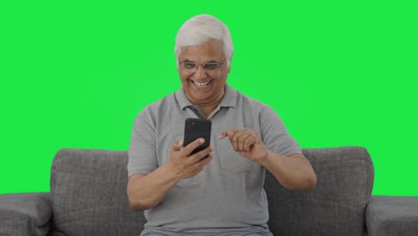 Happy-Indian-old-man-scrolling-through-phone-Green-screen