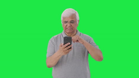 Sleepy-Indian-old-man-scrolling-through-phone-Green-screen