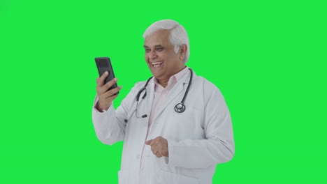 Happy-Indian-senior-doctor-consulting-patient-over-video-call-Green-screen