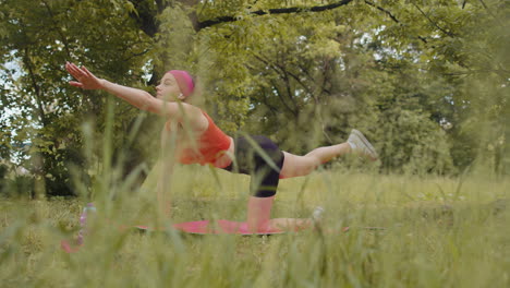 Chica-Atlética-Y-Deportiva-Haciendo-Ejercicio-En-El-Parque-Sobre-Una-Alfombra-Deportiva-Realizando-Entrenamiento-De-Yoga,-Pose-De-Tabla