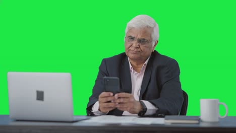 Indian-senior-manager-using-mobile-phone-Green-screen