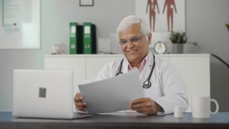 Happy-Indian-senior-doctor-going-through-health-reports