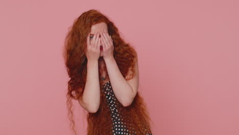 Curious-young-redhead-woman-closing-eyes-with-hand-and-spying-through-fingers,-hiding-and-peeping