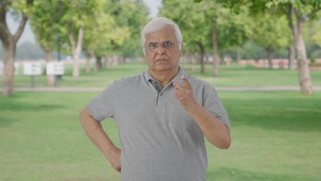 Angry-Indian-old-man-looking-at-the-camera-in-park