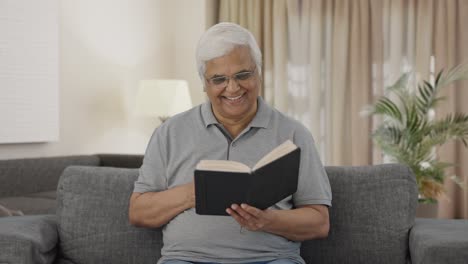 Happy-Indian-old-man-reading-book-in-morning