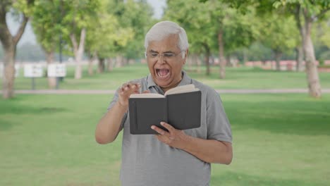 Sleepy-Indian-old-man-reading-a-book-in-park