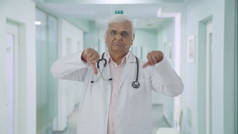 Angry-Indian-senior-doctor-showing-thumbs-down