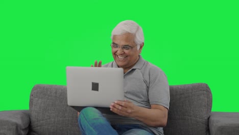 Happy-Indian-old-man-talking-on-video-call-on-laptop-Green-screen