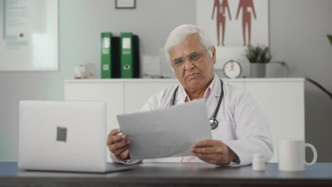 Indian-senior-doctor-reading-health-reports