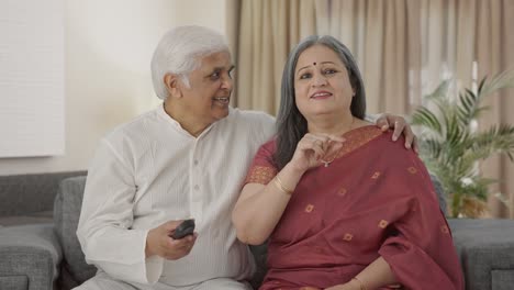 Happy-Old-Indian-couple-watching-TV