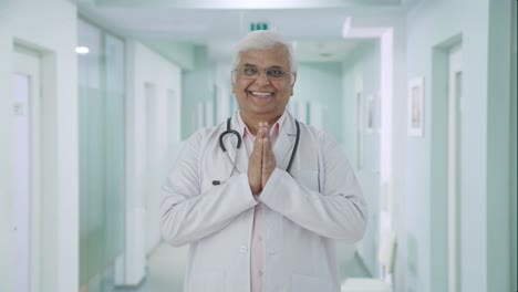 Happy-Indian-senior-doctor-doing-Namaste