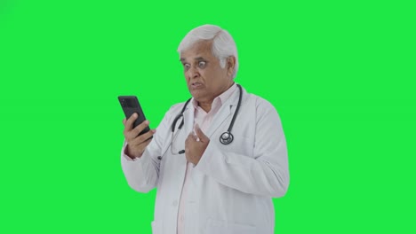 Angry-Indian-senior-doctor-consulting-patient-over-video-call-Green-screen