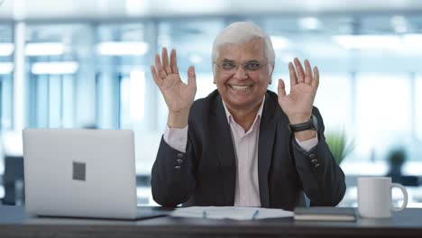 Happy-senior-Indian-businessman-saying-Hello-and-waving