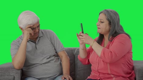 Happy-Old-Indian-wife-clicking-pictures-of-her-husband-Green-screen