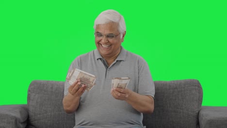 Happy-Indian-old-man-counting-money-Green-screen