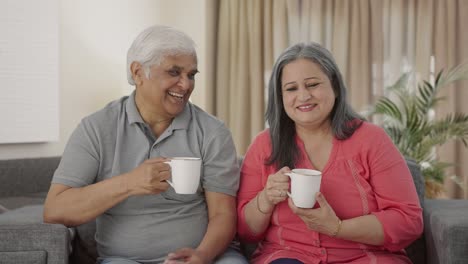 Happy-Indian-old-couple-drinking-tea-and-smiling