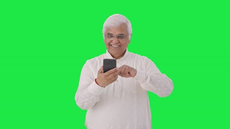 Indian-old-man-scrolling-through-phone-Green-screen