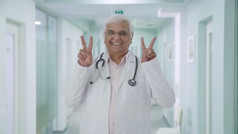 Happy-Indian-senior-doctor-showing-victory-sign