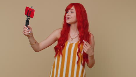 Girl-blogger-take-selfie-on-mobile-phone-selfie-stick-communicate-video-call-online-with-subscribers