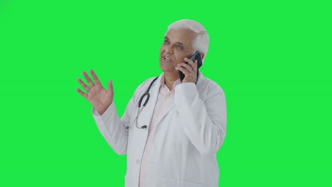 Happy-Indian-senior-talking-to-someone-on-call-Green-screen