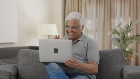 Happy-Indian-old-man-talking-on-video-call-on-laptop