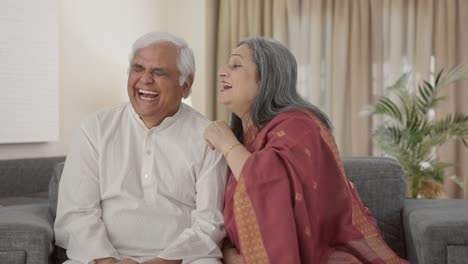 Happy-Old-Indian-wife-telling-a-secret-to-her-husband