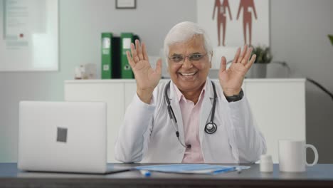 Happy-Indian-senior-doctor-waving-and-saying-Hello