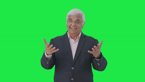 Happy-Indian-senior-manager-talking-to-someone-Green-screen