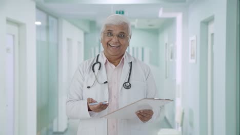 Happy-Indian-senior-doctor-talking-to-the-patient