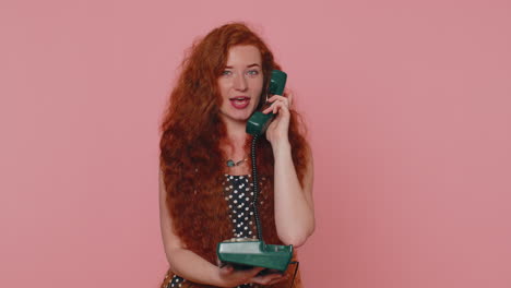 Cheerful-red-hair-girl-secretary-talking-on-wired-vintage-telephone-of-80s,-say-hey-you-call-me-back