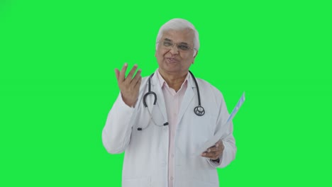 Feliz-Médico-Indio-Explicando-Informes-De-Salud-A-La-Pantalla-Verde-Del-Paciente