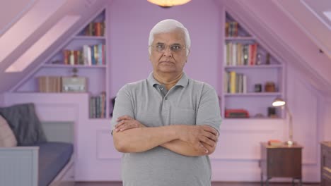 Confident-Indian-old-man-standing-crossed-hands