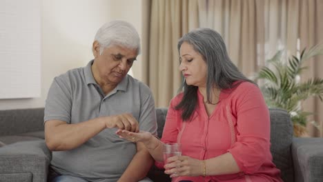 Old-Indian-wife-giving-medicine-to-her-sick-husband